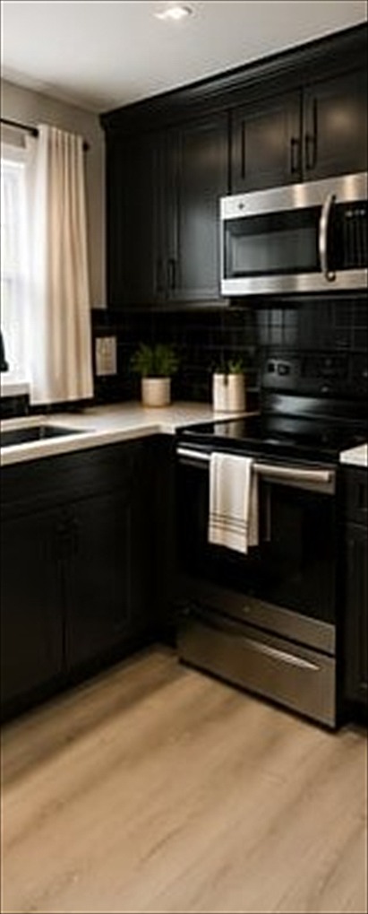Kitchen with dark cabinetry and stainless appliances