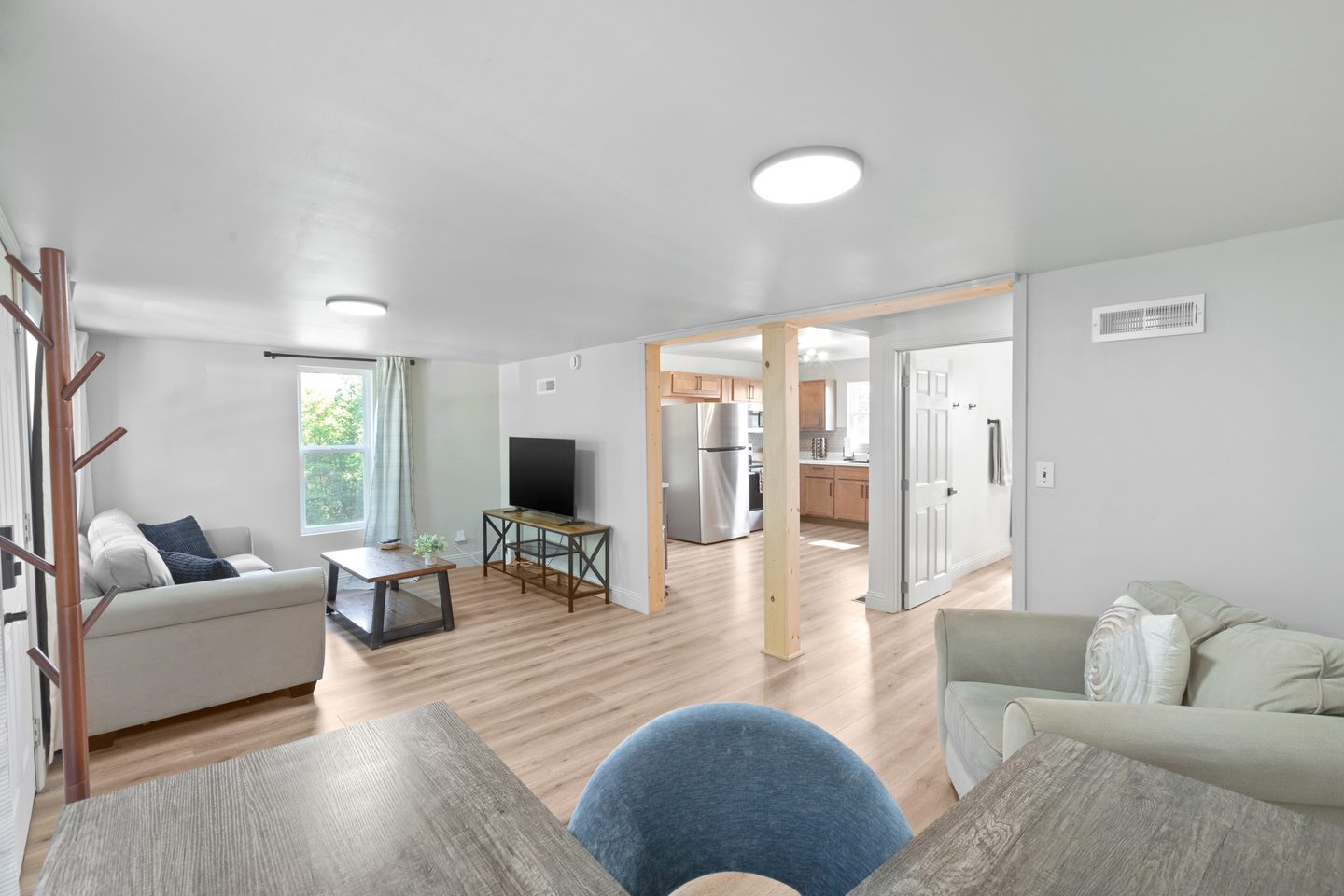 Open living area with sofas, a work desk and a view through to the kitchen