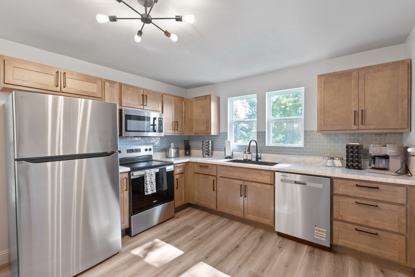 Kitchen with a stainless refrigerator, range, microwave and dishwasher, and a tiled backsplash