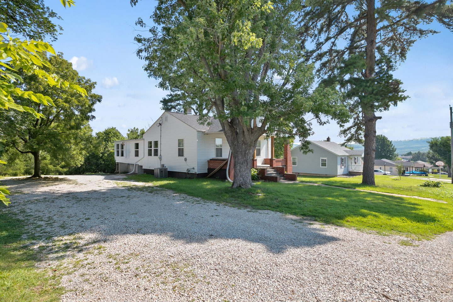 Long gravel driveway beside the house with room for several vehicles