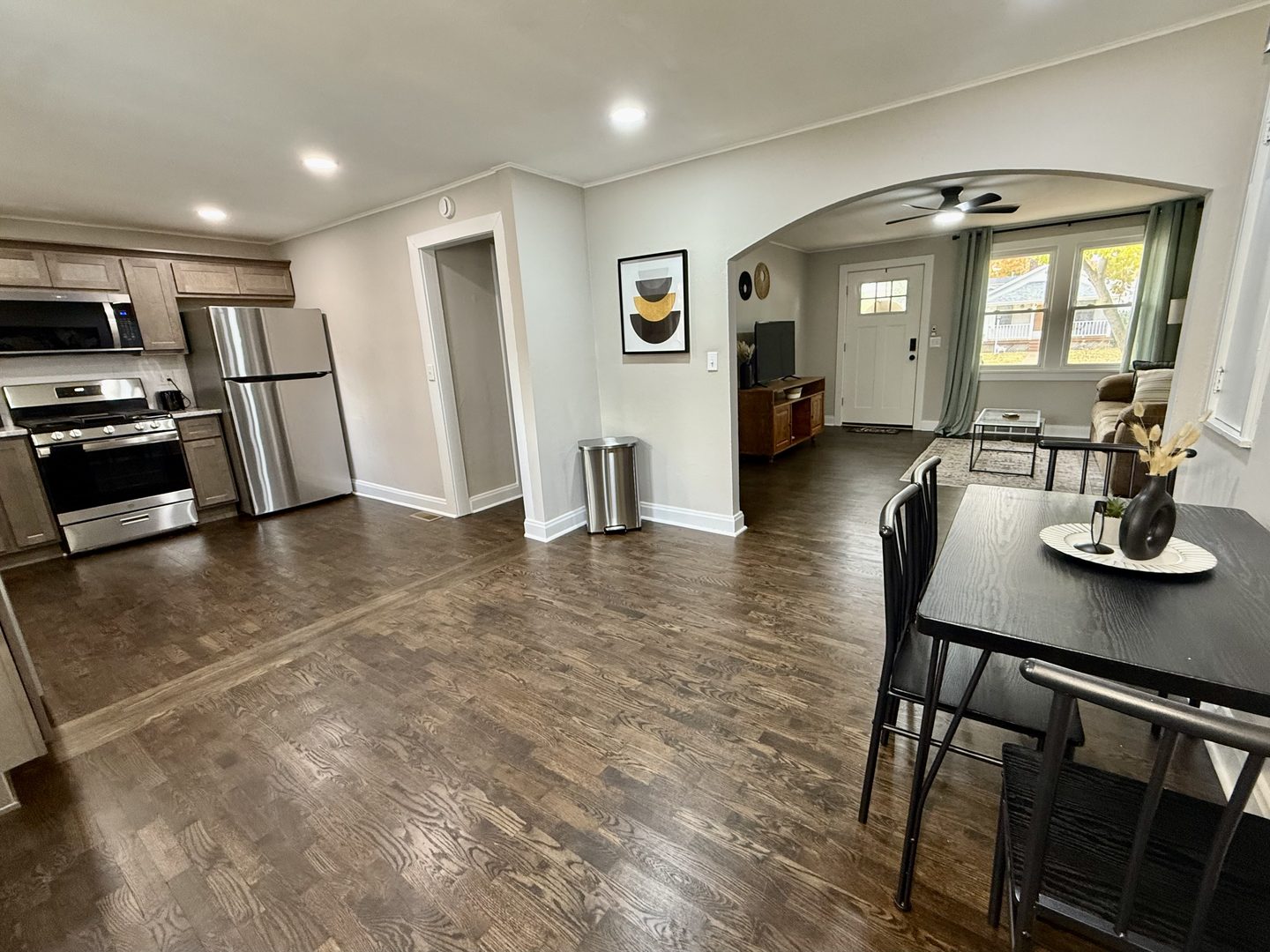 Kitchen opening through to a small dining table and an arched doorway to the living room